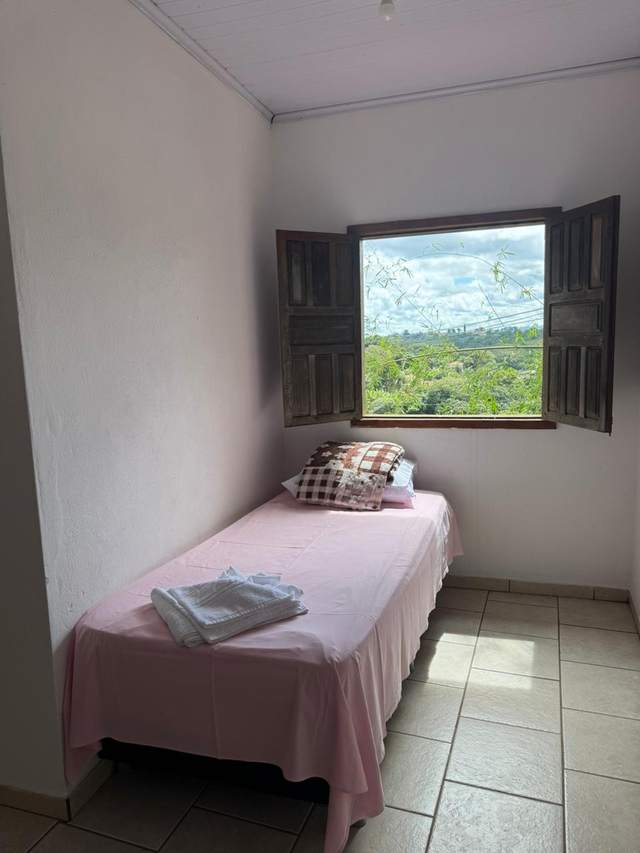 Quarto individual da Pousada das Cores com janela para a mata