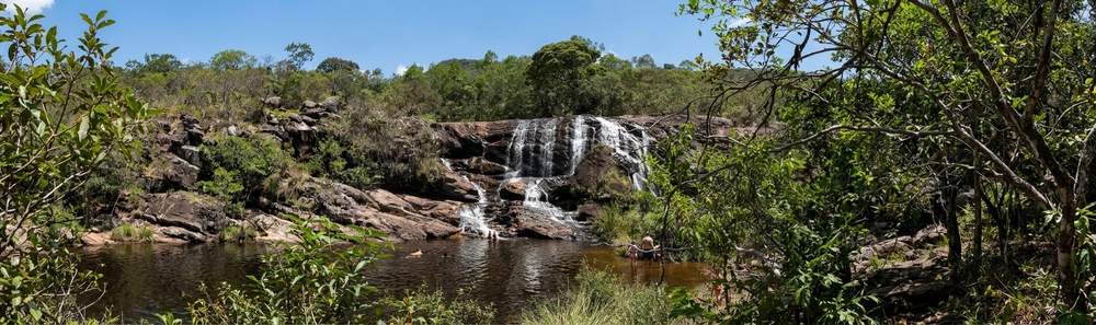 Queda d'água da Cachoeira do Leão entre paredões de rocha e mata nativa em Cocais (MG)